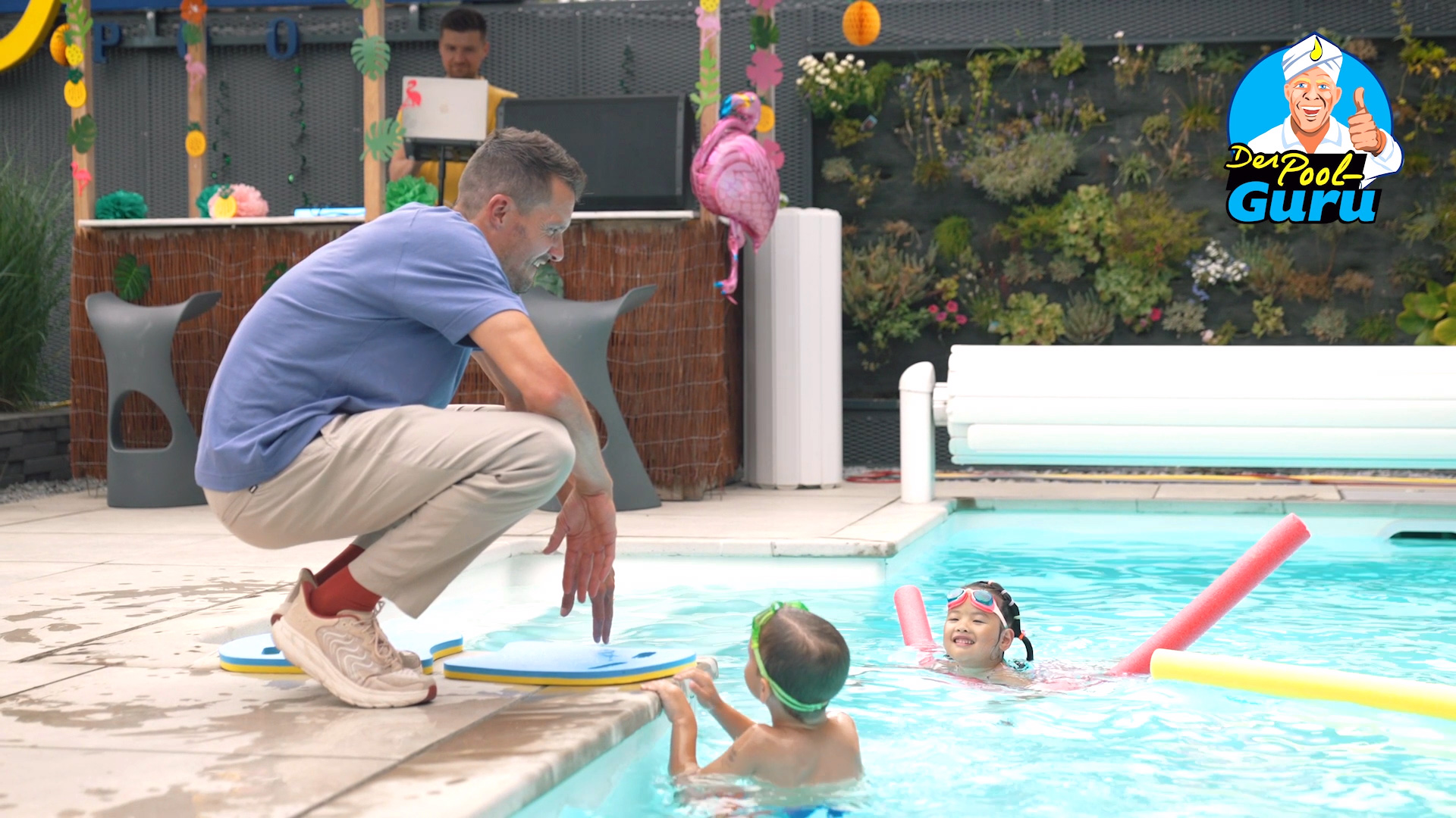 Jan Fordeno gibt Kindern Schwimmtipps am Schwimmbeckenrand